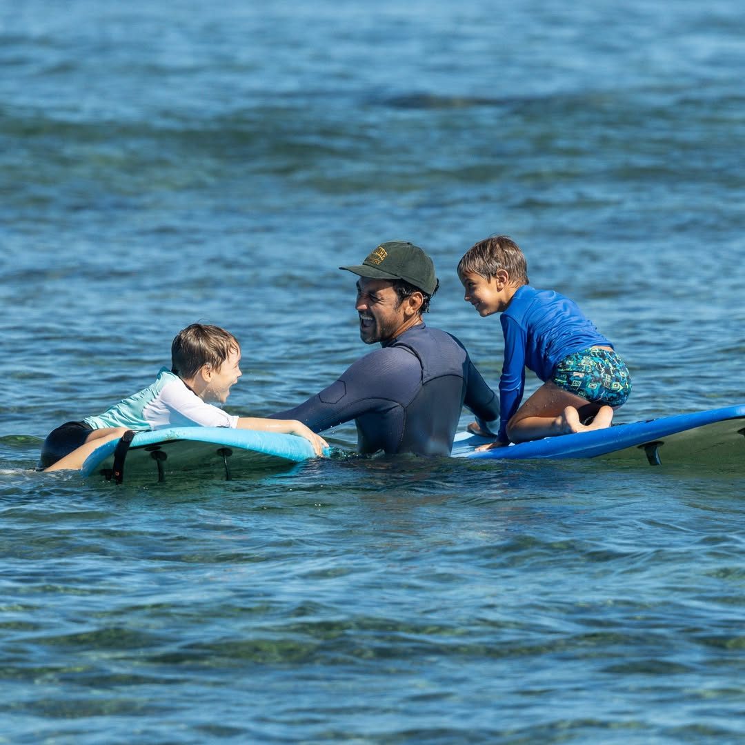 Moniteur Aïko dans l'eau avec deux enfants allongés sur leurs planches